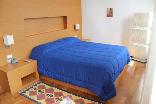 a large blue bed in a room with a table at Arena Verona Centro in Verona