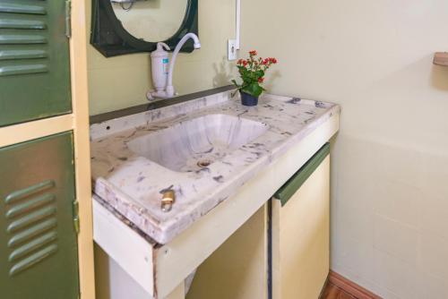 a bathroom sink with a marble counter top at Hostel Multiverso in Santo André