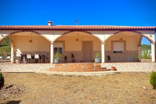 a house with a patio with a table and chairs at Casa Rural La Costa in La Lapa