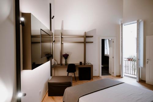 a bedroom with a bed and a desk at Palazzo Garibaldi - Boutique Suites in Barletta