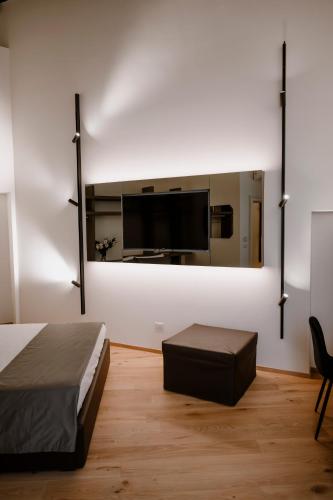 a bedroom with a bed and a tv on a wall at Palazzo Garibaldi - Boutique Suites in Barletta