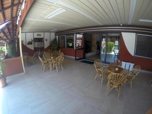 a covered patio with tables and chairs in a building at Residence Hotel Felix in Ricadi