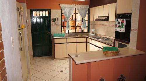 una pequeña cocina con una puerta verde y una encimera en Casa Villa de Leyva en Villa de Leyva