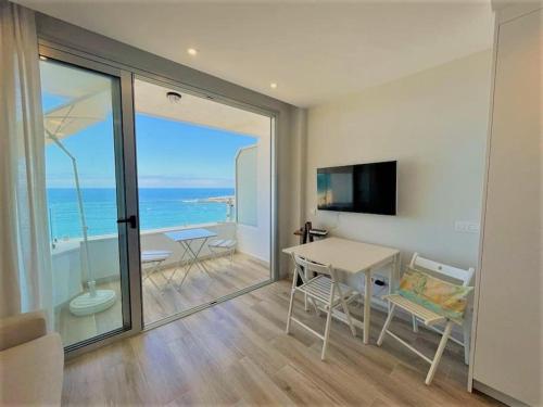 a living room with a table and a view of the ocean at Holidays in My Barra Canteras in Las Palmas de Gran Canaria