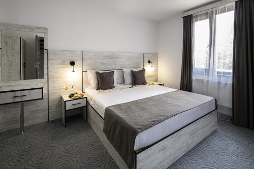 ein Hotelzimmer mit einem großen Bett und einem Spiegel in der Unterkunft Alpina Resort by Stellar Hotels, Tsaghkadzor in Zaghkadsor