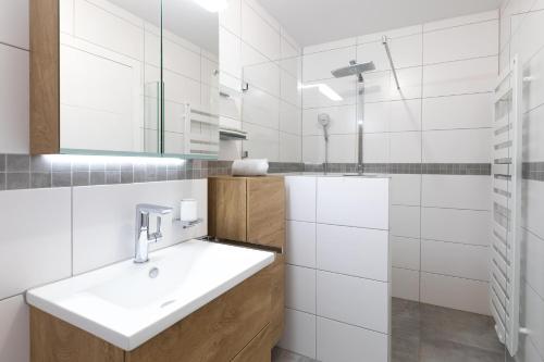 Un baño blanco con lavabo y espejo. en Villa Sohn Deck7, en Juist