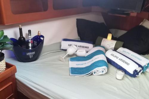 un letto con asciugamani e bottiglie di vino sopra di Boat-Apartamento flotante Cádiz.. La Juanita Arroyo a Cadice