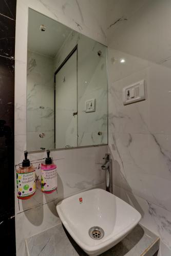 uma casa de banho com um lavatório branco e um espelho. em Hotel Amber Suite Near Mumbai Airport em Mumbai