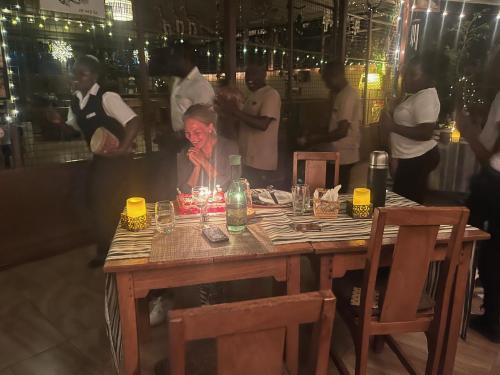 a woman sitting at a table with candles on it at Ikweta Safari Camp in Maua