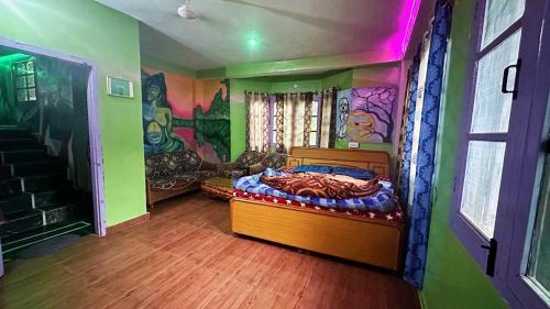 a bedroom with a bed with a painting on the wall at Destination of peace kasol in Kasol