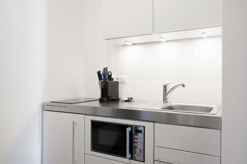 una cucina con lavandino e forno a microonde di easy flat Villach main plaza a Villach