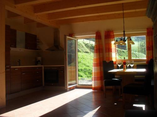 a kitchen with a table and a large window at Bio-Bergbauernhof Möslhof in Aigen im Ennstal