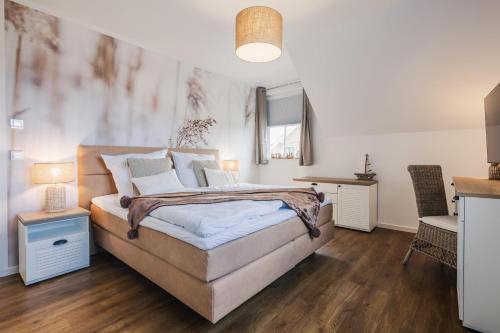 FuhlendorfにあるFerienhäuser Baltic Lagoon Haus 14cの白い壁とウッドフロアのベッドルーム1室