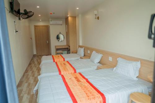 two beds in a hotel room with at Sea Balcony Hotel in Cat Ba