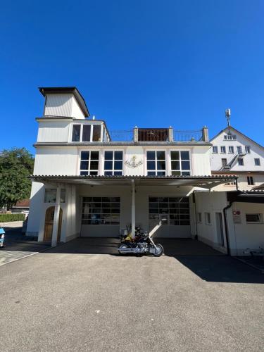 un edificio blanco con una motocicleta estacionada en un estacionamiento en Luxus-Loft Atrium -X-, en Rorbas