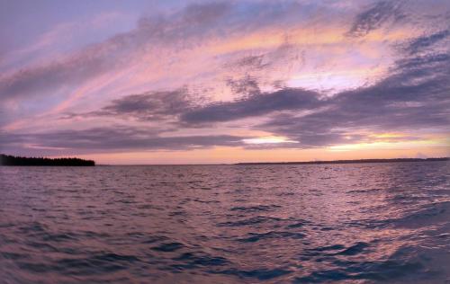 a sunset over a large body of water at Munroe Inn Homestay in Kollam