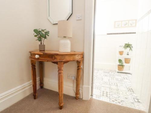 a table with a lamp on it next to a door at 53A Princes Crescent in Morecambe