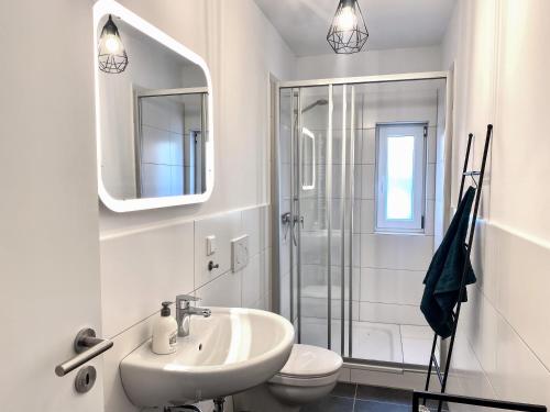 a white bathroom with a sink and a shower at Olivia in Tholey