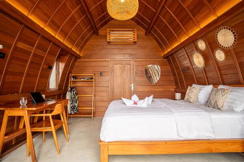 ein Schlafzimmer mit einem Bett und einem Schreibtisch in einem Zimmer in der Unterkunft HIMA Bungalows in Lagudri