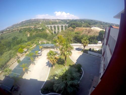 a view of a resort with palm trees and a mountain at Residence Hotel Felix in Ricadi