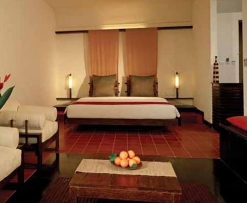 a hotel room with a bed and a bowl of fruit at Rainforest Resort in Athirappilly