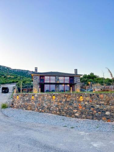 a house on top of a stone wall at Modern Stone Villas with Swimming Pool in Aliveri