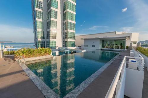 un grand bâtiment avec une piscine en face d'un bâtiment dans l'établissement Maritime Suite by AirRise, à Jelutong
