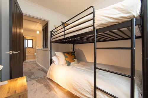 a bedroom with two bunk beds and a hallway at Parf’s Place, Troedyrhiw near Bike Park Wales in Troed-y-rhiw