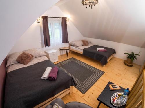 een slaapkamer op zolder met 2 bedden en een tafel bij Domek, agroturystyka Pod Gwiazdami Ropa in Ropa