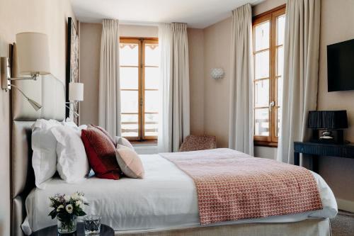 a bedroom with a bed with flowers on it at Hotel Le Cottage Bise in Talloires