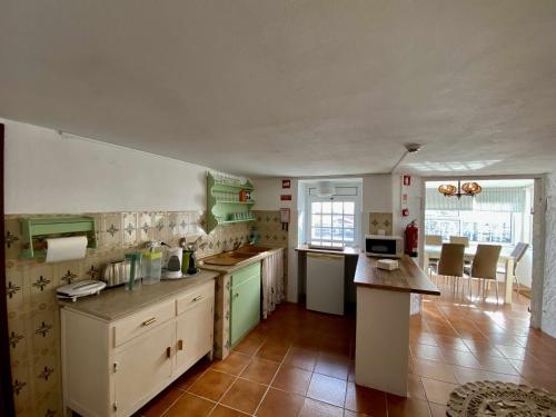 uma cozinha com armários verdes e brancos e uma mesa em Solar Laginha - apartamentos, quartos, camas em dormitório em Afife