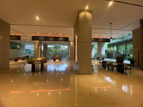 un hall avec des tables et des chaises dans un bâtiment dans l'établissement Home Resort KLCC by Calm Sojourn, à Kuala Lumpur