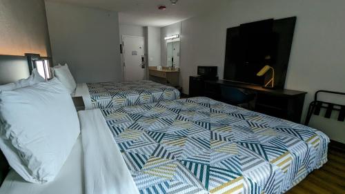 a hotel room with two beds and a flat screen tv at Motel 6-Leominster, MA in Leominster