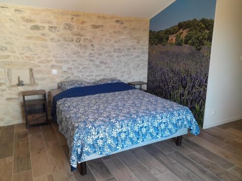 - une chambre avec un lit et un mur orné d'une fresque murale dans l'établissement Beaux Yeux, à Montségur-sur-Lauzon