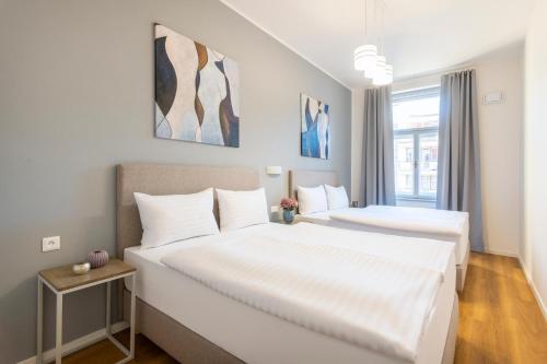 a bedroom with two beds with white sheets at Hidden Art Boutique Residence by Dwellfort in Prague