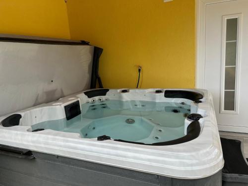 eine Whirlpool-Badewanne in einem Zimmer mit gelber Wand in der Unterkunft Abacus House in Csopak