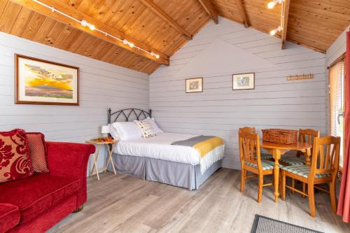 um quarto com uma cama, uma mesa e um sofá em Broom Leisure em Annan