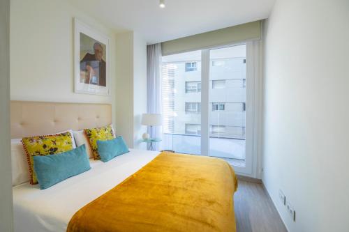 1 dormitorio con 1 cama grande y ventana grande en Las Canteras Suite en Las Palmas de Gran Canaria