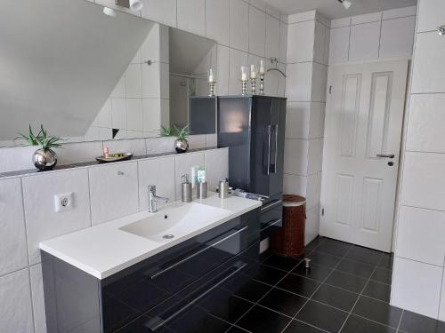 a bathroom with a sink and a mirror at Villa FH Mechthild in Dörpen