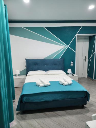 a bedroom with a blue bed with two pillows at Gradini Partenopei in Naples