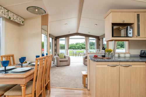 uma cozinha e sala de estar com uma mesa e uma sala de jantar em Broom Leisure em Annan