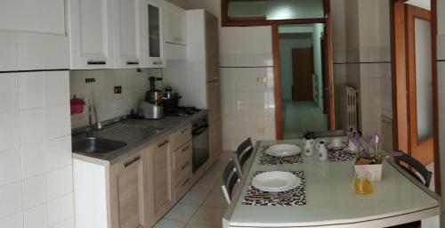 una cocina con una mesa con platos. en IN CENTRO APARTMENT, en Melfi