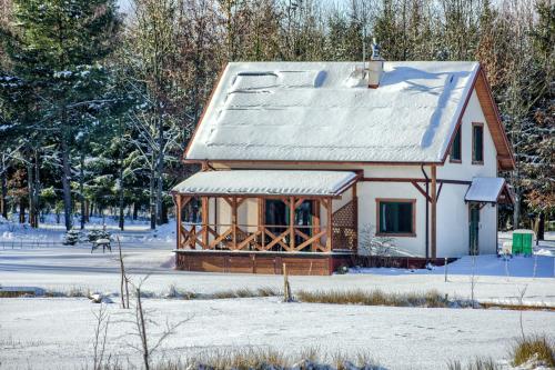 a log cabin in the winter with snow on the ground at Rentynówka in Gietrzwałd