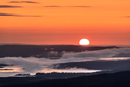 a view of the sun rising above the clouds at Vålådalens Fjällstation in Vålådalen