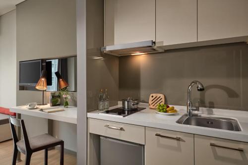 a kitchen with a sink and a counter top at Novotel Living Saigon South in Ho Chi Minh City