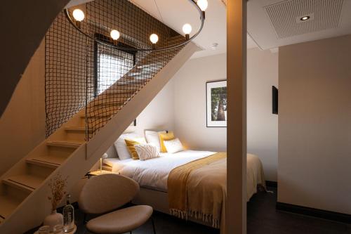 a bedroom with a bed and a stairway with a bed and a stair railing at Hotel Kint in Valkenburg