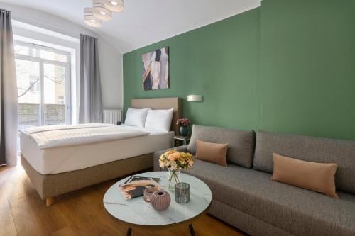a bedroom with a bed and a couch and a table at Hidden Art Boutique Residence by Dwellfort in Prague