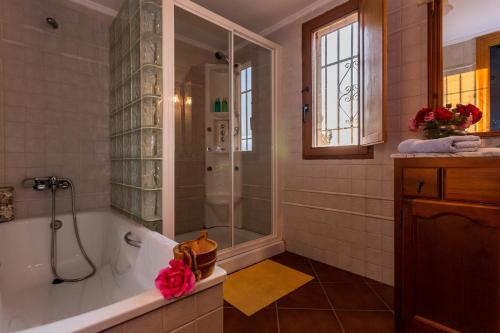 a bathroom with a tub and a shower with a shower at Casa Rural Finca Las Picazas in Peñarroya-Pueblonuevo