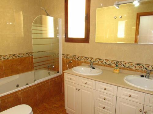 a bathroom with two sinks and a tub and a toilet at Penthouse Benalvistas Torregolf Seaview in Benalmádena