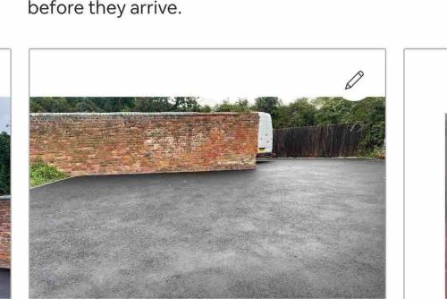 a garage with a brick wall and a truck at The Hurst Coach House in Stafford